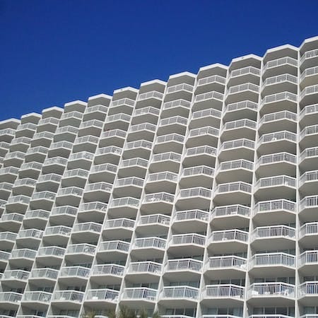 a tall white building with a blue sky in the background